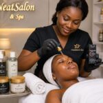 African woman applying Vitamin C serum on her client's facial with skincare products for radiant complexion in a facial spa in Nigeria.