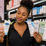 15 Best Face Scrubs for Glowing Skin in Nigeria: Reviews & Buying Guide African woman comparing popular face scrubs for glowing skin in a Nigerian skincare store.