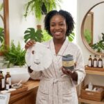 Sheet Mask vs Clay Mask: Which Is Better for Your Skin? African woman comparing a sheet mask and clay mask during a skincare routine for healthy, glowing skin.