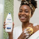 African woman using shower gel during a refreshing shower routine for clean, soft and glowing skin in Nigeria.